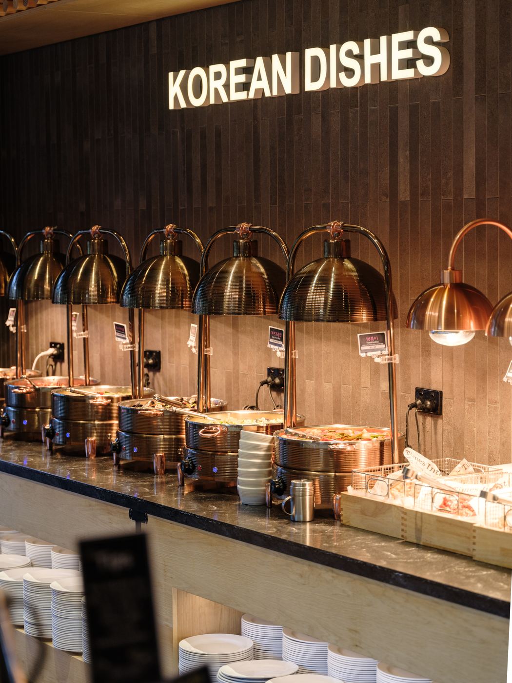 Copper carvery lamps over a stone and stainless buffet counter