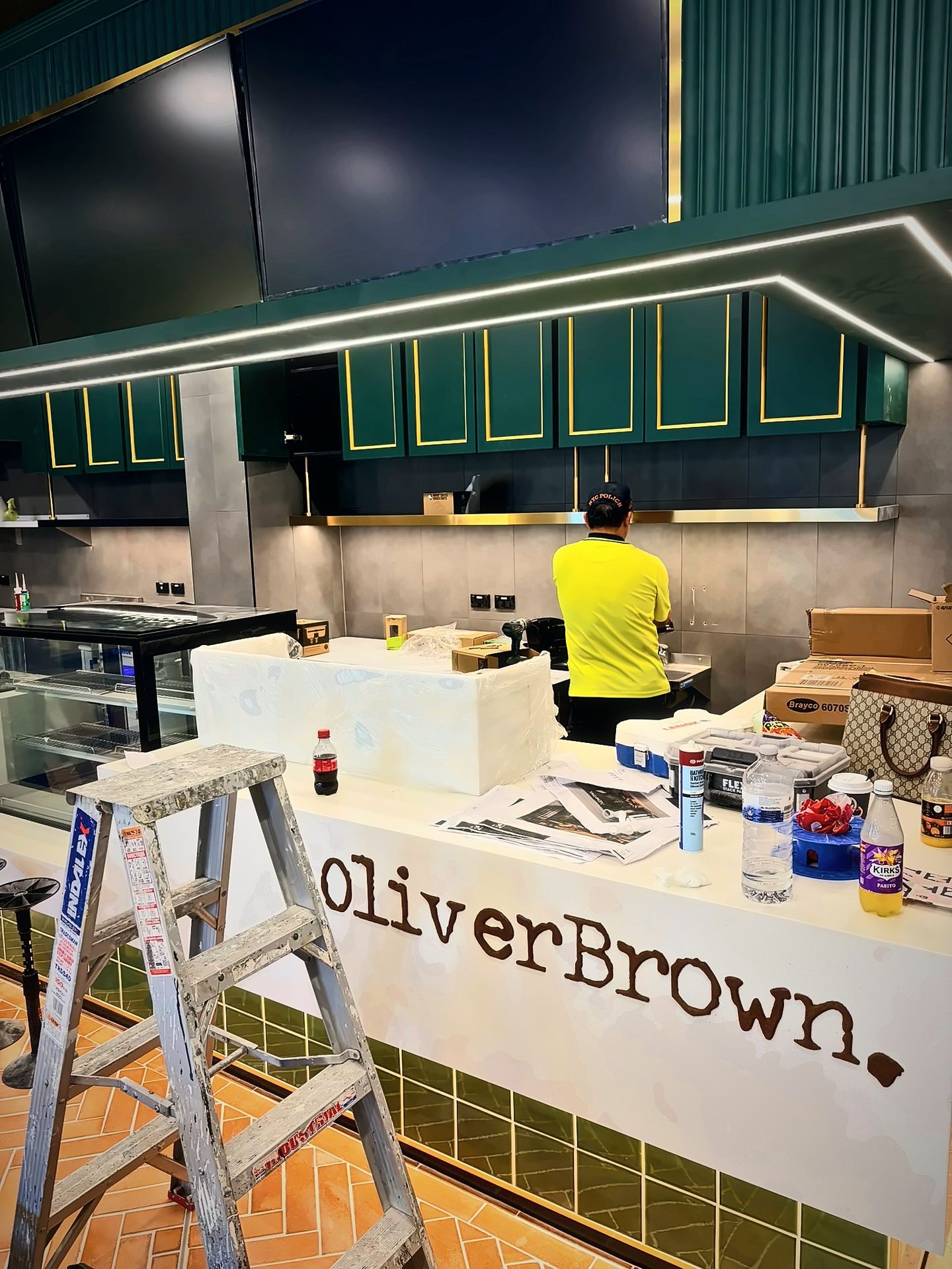 Stone counter with raised OliverBrown lettering over a green tiled plinth